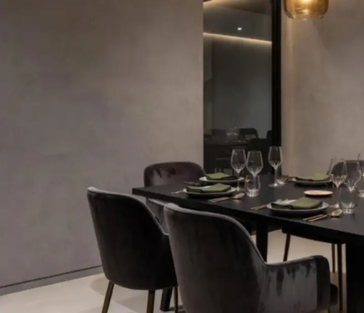 Private dining room with moody lighting and a long table set for an intimate gathering